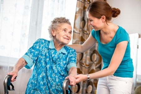 Caregiver Helping Elderly Woman At Home