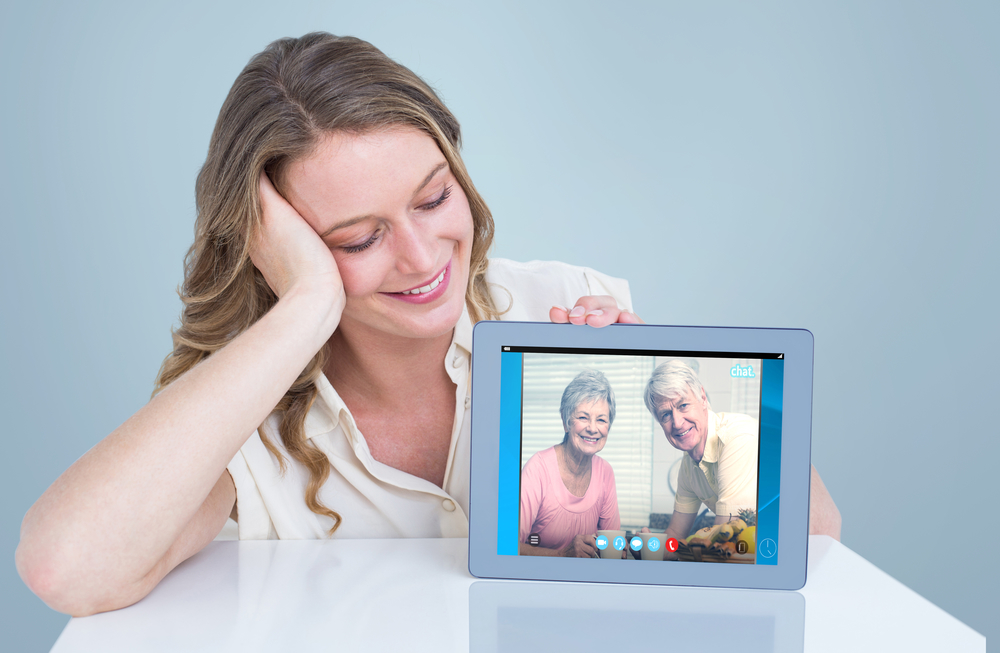 A woman connecting with elderly family members long-distance using a video chat